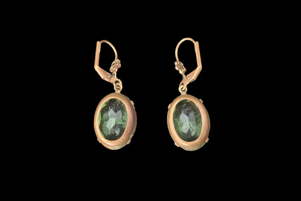 Horizontal back view of 2010s vintage faceted glass oval peridot green rhinestone and brass lever back drop earrings made from vintage components.