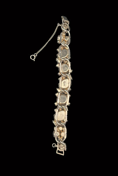 Vertical back view of 1950s vintage Weiss autumnal orange, brown, and iridescent rhinestone and foil backed glass cabochon gold tone bracelet.