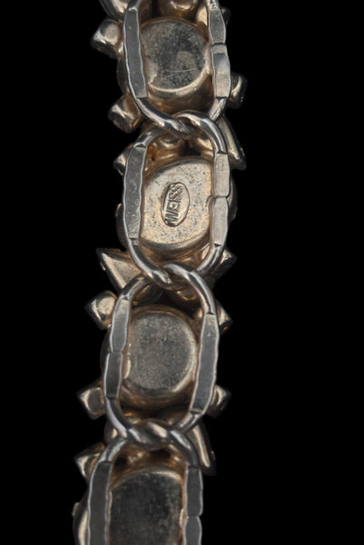 Detail view of 1950s vintage Weiss autumnal orange, brown, and iridescent rhinestone and foil backed glass cabochon gold tone bracelet. Showing the Weiss stamp on the back of the bracelet.