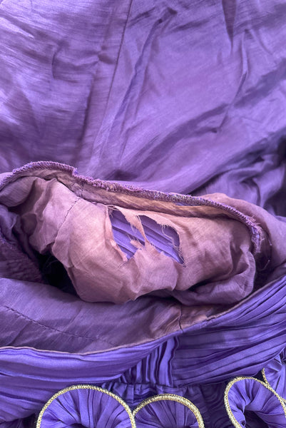 Interior detail view of 1980s vintage purple peated satin dress with purple and gold ruffled statement sleeves by Richilene, size medium to large. Showing discoloration and damage to the silk lining under the arm.