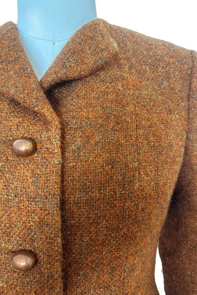 Detail view of 1960s vintage rust brown wool, three copper metal button, long sleeve jacket by Pauline Trigère for Bergdorf Goodman, size medium to large. Showing a close-up of the turned down collar and bean shaped copper buttons.