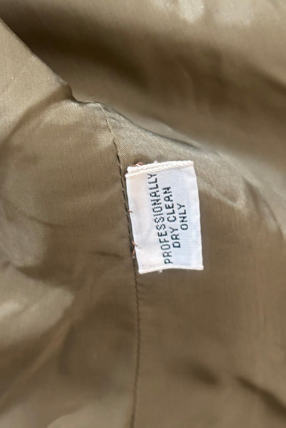Interior detail view of 1960s vintage rust brown wool, three copper metal button, long sleeve jacket by Pauline Trigère for Bergdorf Goodman, size medium to large. Showing the dry clean only tag.