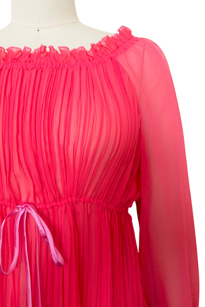 Detail view of new with tags deadstock 2000s vintage y2k coral pink pleated, empire waist, long sleeve chiffon mini baby doll nightgown by Romance for Nk Imode, size large to extra large. Showing the round, ruffled elastic neckline and contrasting pink satin drawstring at the empire waistline.