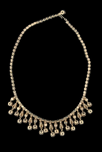 Vertical back view of 1950s vintage pink & gray round and pear cut rhinestone gold tone necklace and earrings demi-parure jewelry set. Showing the back side of the necklace with its gold tone setting.