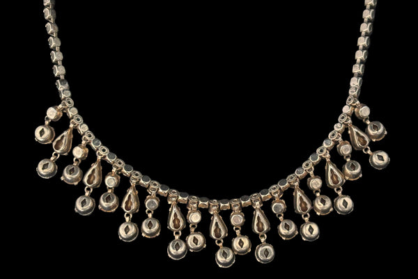 Detail back view of 1950s vintage pink & gray round and pear cut rhinestone gold tone necklace and earrings demi-parure jewelry set. Showing the back side of the necklace with its gold tone setting.