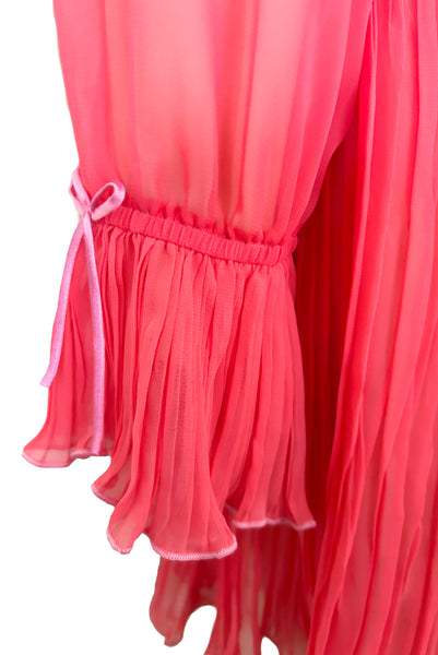 Detail view of new with tags deadstock 2000s vintage y2k coral pink pleated, empire waist, long sleeve chiffon mini baby doll nightgown by Romance for Nk Imode, size large to extra large. Showing the elastic, ruffled, pleated cuff with pink satin bow.