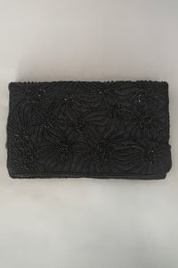Vertical front view of 1960s vintage black satin floral beaded fold over clutch evening bag by Walborg.
