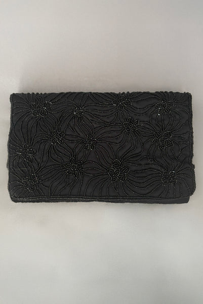 Vertical front view of 1960s vintage black satin floral beaded fold over clutch evening bag by Walborg.
