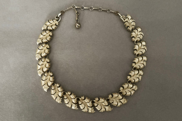 Horizontal front view of 1950s vintage champagne gold tone leaf adjustable necklace by Lisner.