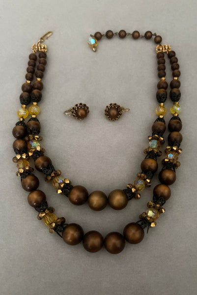Vertical view of 1950s vintage brown and yellow double strand beaded necklace and clip-on earrings demi parure set by Hobé.