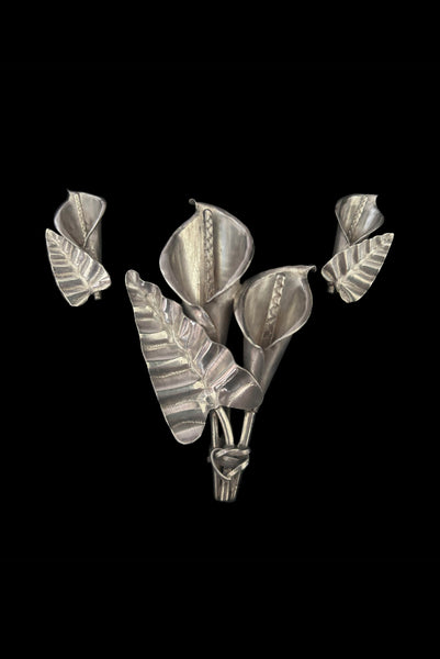 Vertical front view of 1950s vintage Mexican silver calla lily engraved floral brooch and screw back earrings jewelry set.