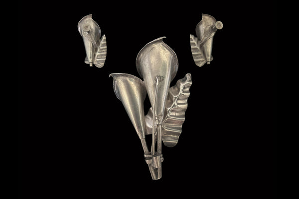 Horizontal back view of 1950s vintage Mexican silver calla lily engraved floral brooch and screw back earrings jewelry set.