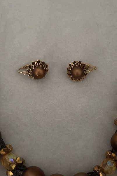 Vertical view of 1950s vintage brown and yellow double strand beaded necklace and clip-on earrings demi parure set by Hobé. Showing the earrings alone.