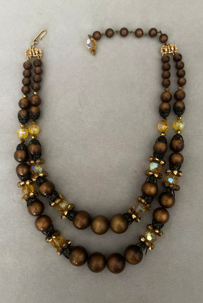 Vertical view of 1950s vintage brown and yellow double strand beaded necklace and clip-on earrings demi parure set by Hobé. Showing the necklace alone.