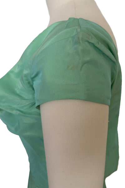 Side detail view of 1950s vintage mint green iridescent taffeta shelf bust wiggle cocktail dress with balloon train by Kay Selig, extra extra small to extra small. Showing a small spot on the cap sleeve.