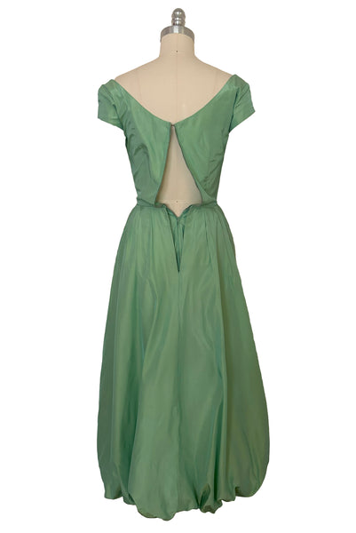 Back view of 1950s vintage mint green iridescent taffeta shelf bust wiggle cocktail dress with balloon train by Kay Selig, extra extra small to extra small.