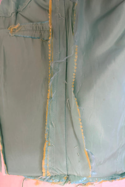 Interior detail view of 1950s vintage mint green iridescent taffeta shelf bust wiggle cocktail dress with balloon train by Kay Selig, extra extra small to extra small. Showing the seam allowances and that the dress has been taken in.
