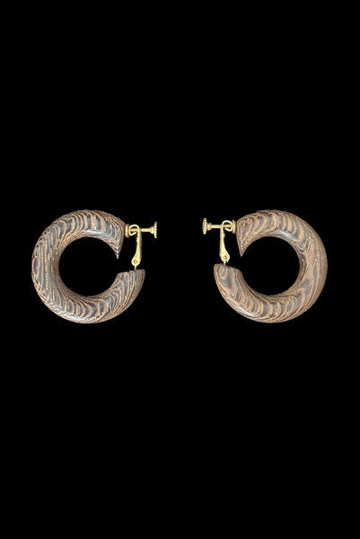 Vertical side view of 1980s vintage blonde and dark brown two tone wood hoop clip-on adjustable earrings.