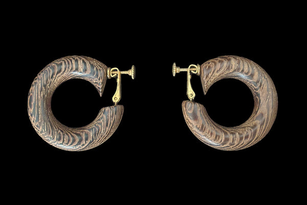 Horizontal side view of 1980s vintage blonde and dark brown two tone wood hoop clip-on adjustable earrings.