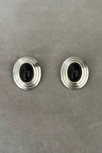 Vertical front view of 1980s vintage 925 sterling silver and onyx cabochon oval clip-on earrings, by Christian Dior.