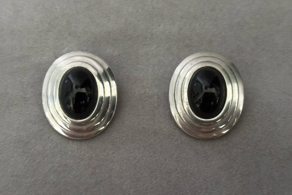 Horizontal front view of 1980s vintage 925 sterling silver and onyx cabochon oval clip-on earrings, by Christian Dior.