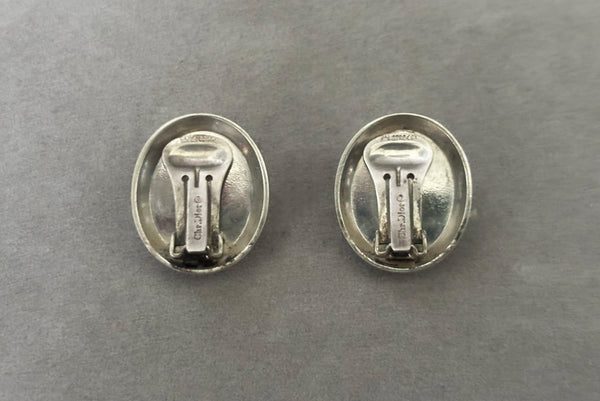 Horizontal back view of 1980s vintage 925 sterling silver and onyx cabochon oval clip-on earrings, by Christian Dior.