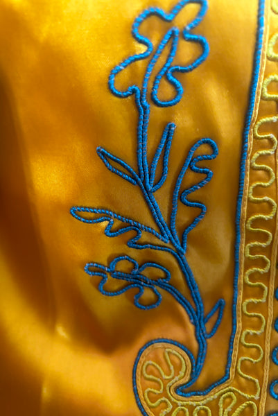 Front detail view of 1920s vintage mustard yellow and cream satin regalia robe w/ teal blue soutache embroidery, by Ihling Brothers Everard Co. Fits most sizes. Showing the blue and yellow corded embroidery.