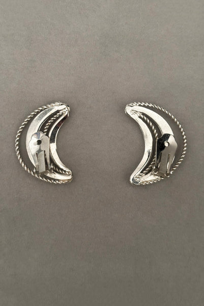 Vertical back view of 1980s vintage silver tone crescent clip-on statement earrings by Bergere.