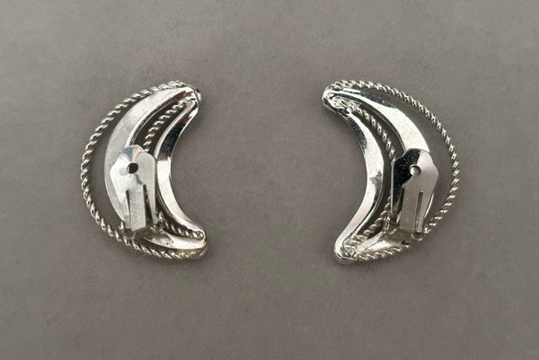 Horizontal back view of 1980s vintage silver tone crescent clip-on statement earrings by Bergere.