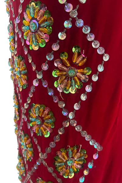 Sleeve detail view of 1960s vintage Mardi Gras costume red velvet beaded caftan/dress, small to medium. Showing the pink, green, blue, yellow, and clear sequins, plastic beads, and glass beads.