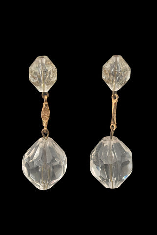 Vertical front view of 1960s vintage mod clear faceted Lucite bead and gold tone metal top and drop clip-on earrings.
