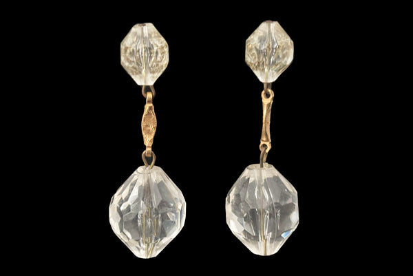 Horizontal front view of 1960s vintage mod clear faceted Lucite bead and gold tone metal top and drop clip-on earrings.