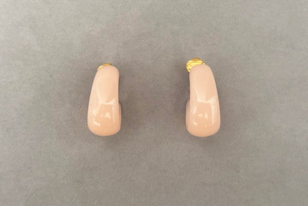 Horizontal front view of 1980s vintage pink Lucite plastic and gold tone clip-on hoop earrings by Crown Trifari.