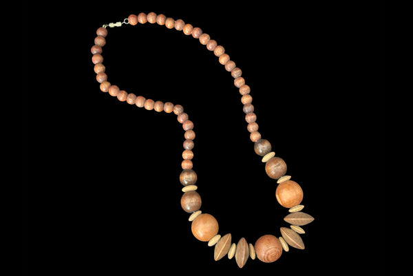 Horizontal view of 1980s vintage carved round and disk bead light, medium, and dark triple tone wood necklace.