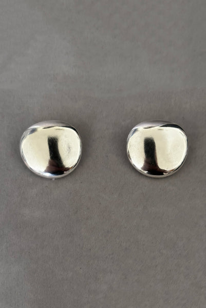 Vertical front view of 1980s vintage polished silver tone irregular oval organic clip-on earrings.