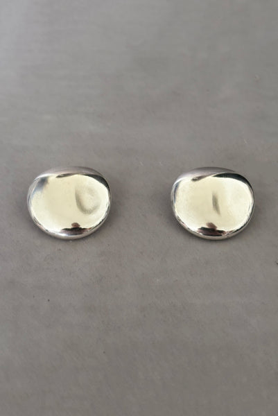 Vertical perspective view of 1980s vintage polished silver tone irregular oval organic clip-on earrings.