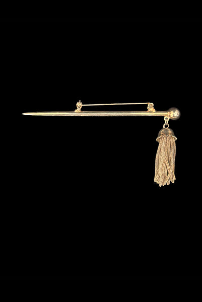 Vertical top view of 1960s vintage gold tone bar brooch with metal mesh tassel.