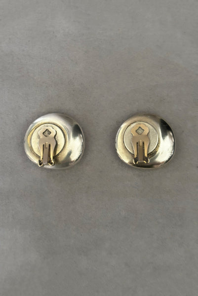 Vertical back view of 1980s vintage polished silver tone irregular oval organic clip-on earrings.