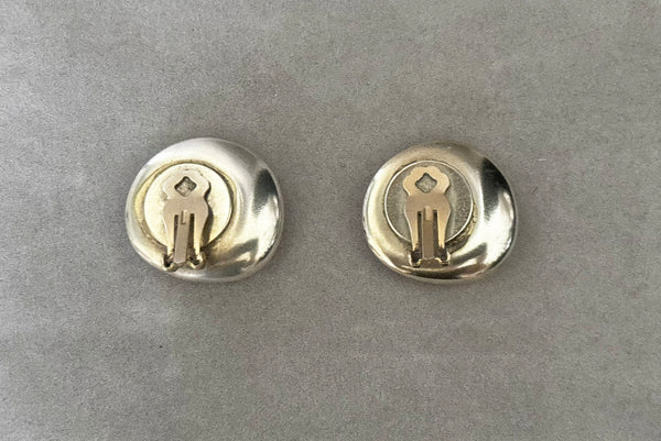 Horizontal back view of 1980s vintage polished silver tone irregular oval organic clip-on earrings.