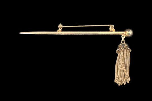 Horizontal top view of 1960s vintage gold tone bar brooch with metal mesh tassel.