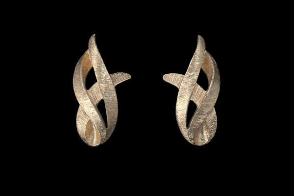 Horizontal front view of 1960s vintage brushed gold tone flame clip-on earrings by Monet.