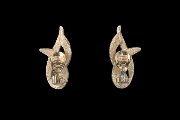 Horizontal back view of 1960s vintage brushed gold tone flame clip-on earrings by Monet.