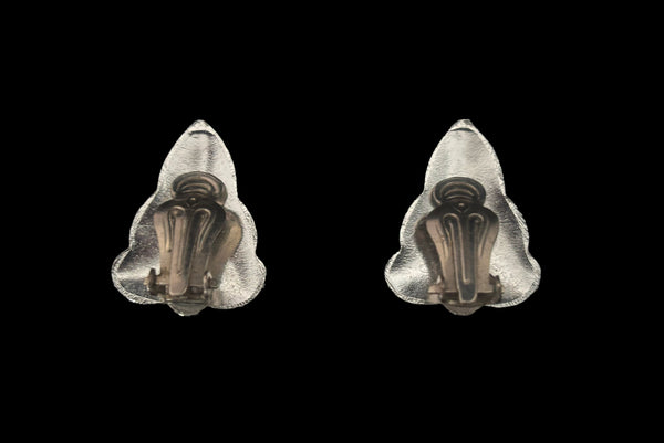 Horizontal back view of 1960s vintage silver tone and black floral scalloped triangular clip-on earrings for unpierced ears.