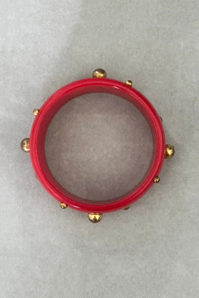 Vertical bottom view of 1940s vintage brass studded rich cherry red Bakelite statement bangle bracelet.
