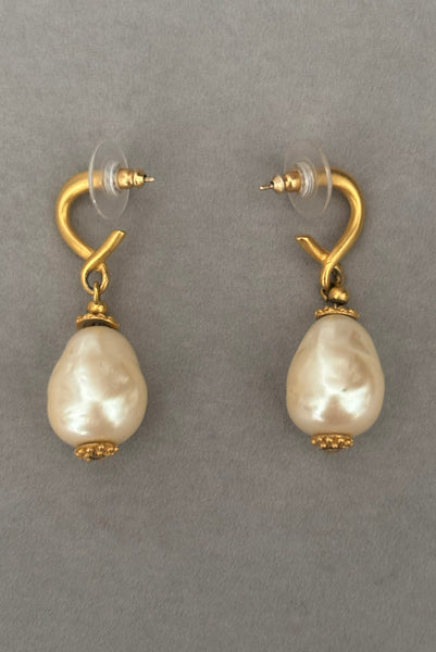 Vertical side view of 1990s vintage gold tone matte metal and cream faux pearl pierced drop earrings.
