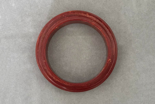 Horizontal top view of 1940s vintage groove carved rust and yellow marbled Bakelite bangle bracelet.