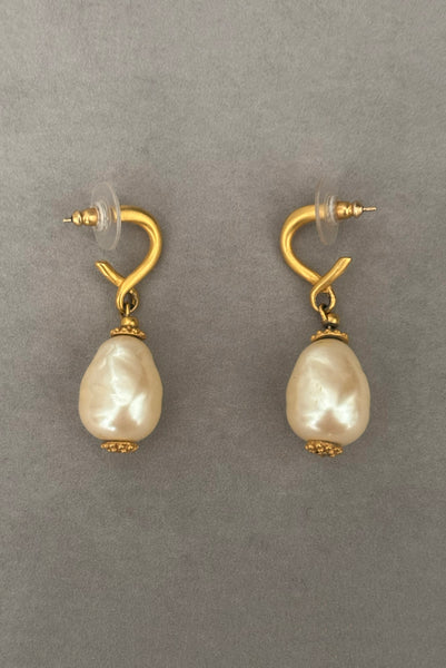 Vertical side view of 1990s vintage gold tone matte metal and cream faux pearl pierced drop earrings.