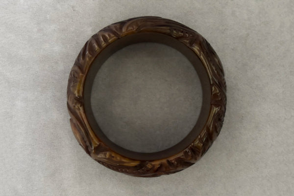 Horizontal top view of 1930s vintage novelty octopus sea life carved green Bakelite statement bangle bracelet.