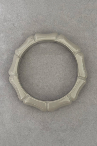 Vertical top view of 2000s y2k vintage gray plastic molded faux bamboo bangle bracelet.