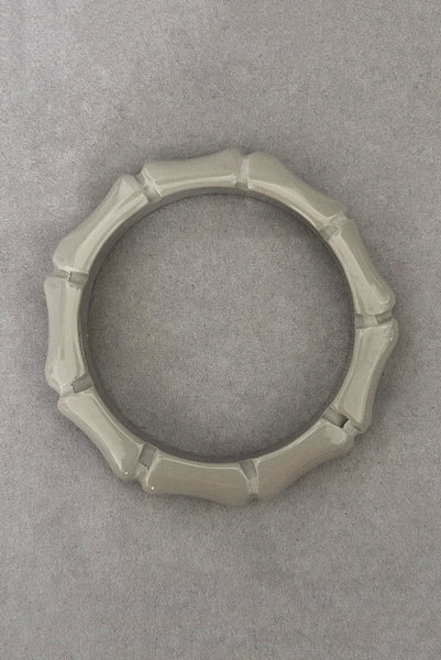 Vertical bottom view of 2000s y2k vintage gray plastic molded faux bamboo bangle bracelet.